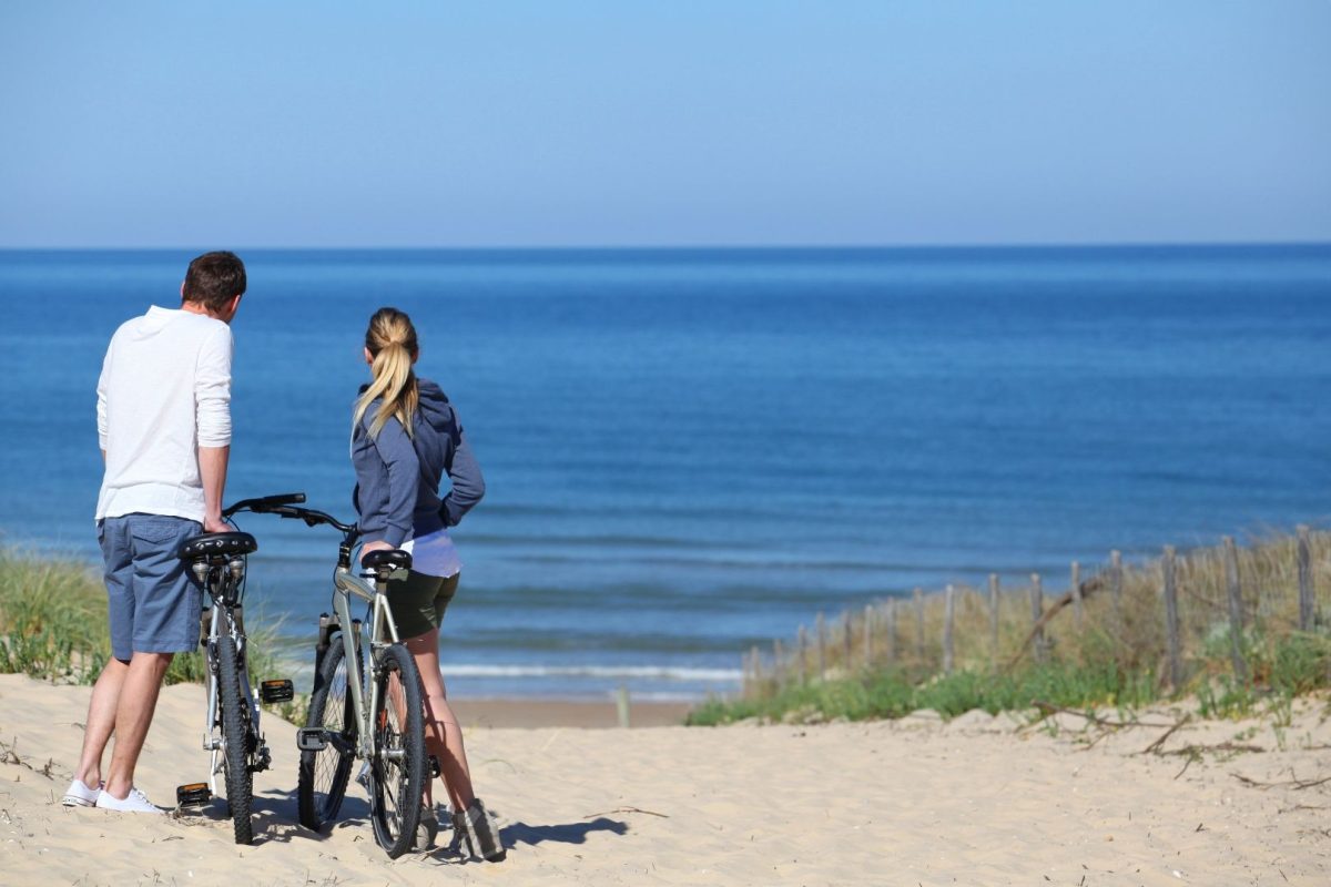 couple with bikes by beach