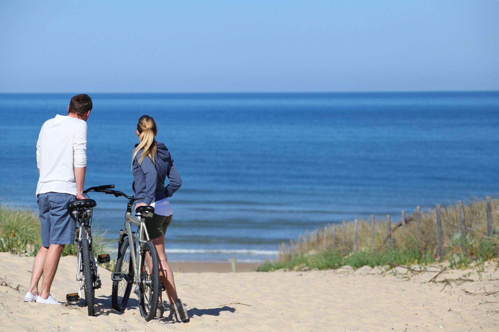 couple with bikes by beach