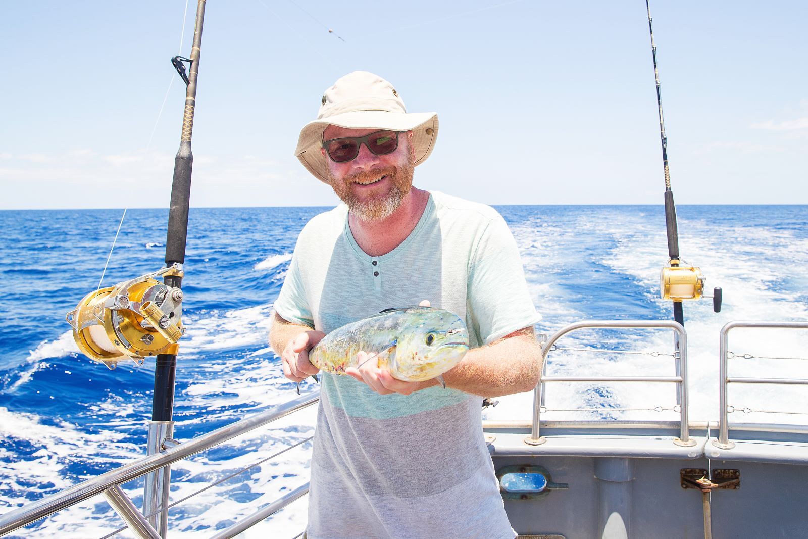 older man holding a fish that he caught