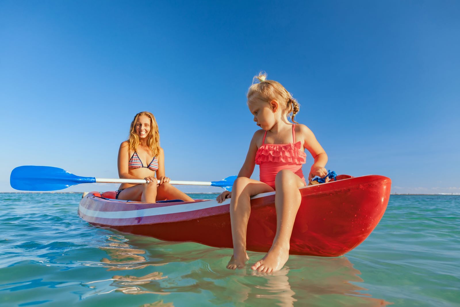 kid and older adult siting in kayak