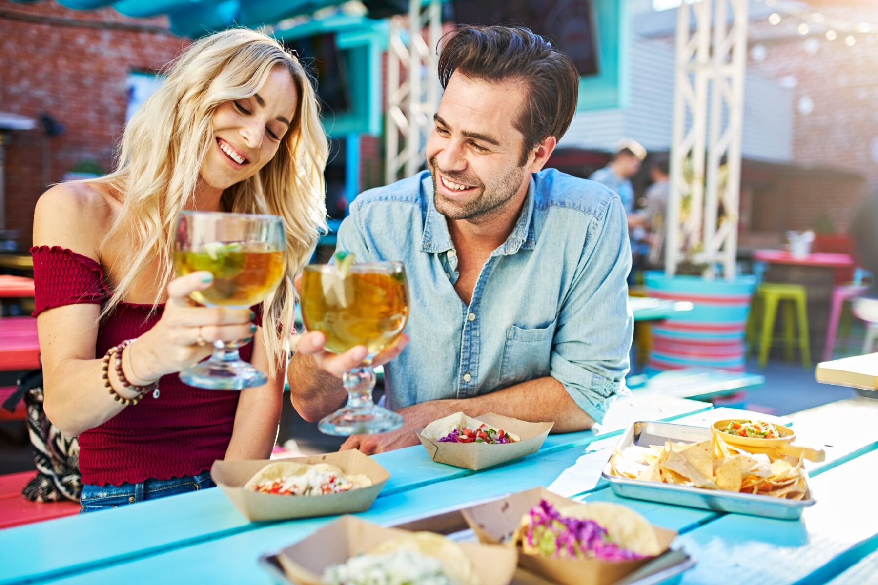 Couple having drinks and tacos at a restaurant.